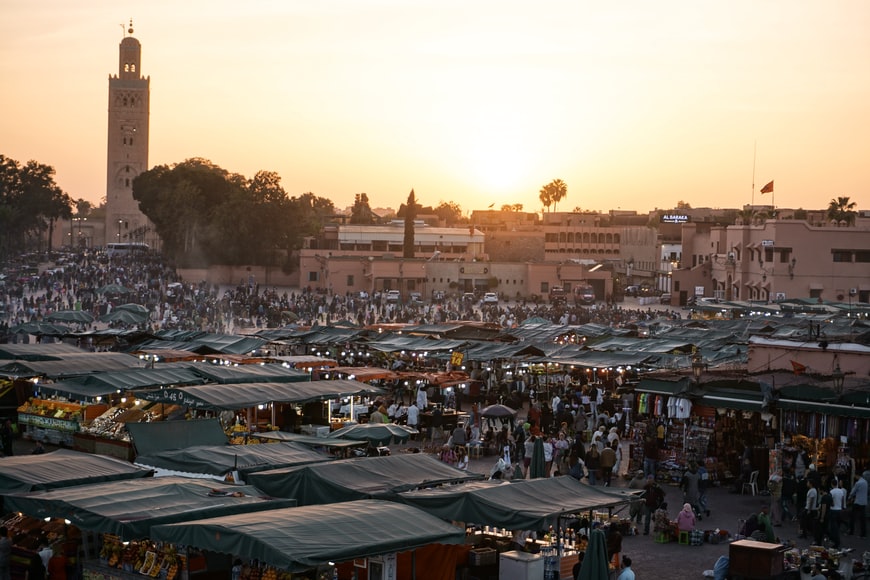 A silhouetted skyline of Marrakech against the evening sun