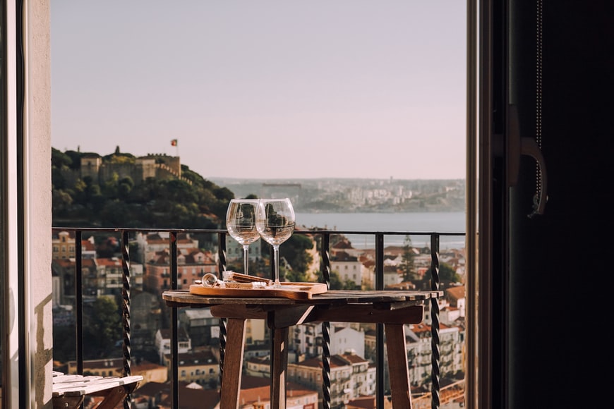 Empty wine glasses strewn on a table over looking Lisbon's skyline … the sign of a good time had.